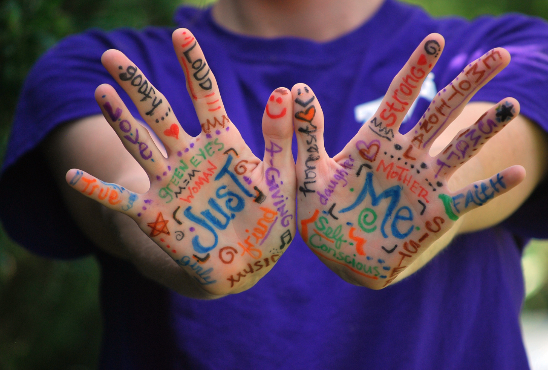 A close up of the palms of someone's hands which are painted with words