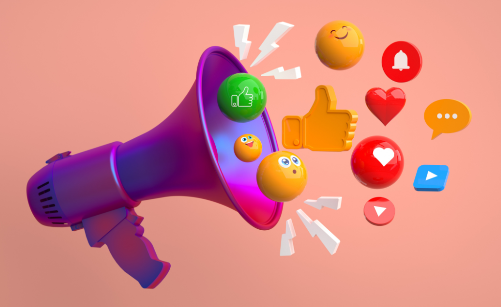 Colourful megaphone on a pink background with various social media icons and emojis, including thumbs-up, heart, bell, smiley face, speech bubble, and play button, emerging from it.
