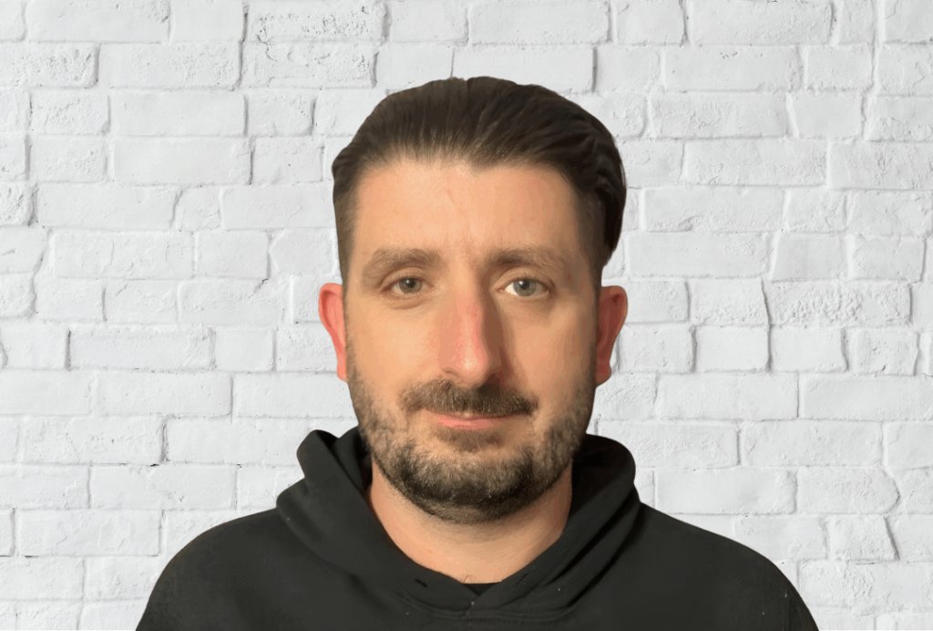 Headshot of Stephen Maguire, an SEA Advocate Officer at EPIC. He has short dark brown hair, he has a beard and mustache, and is wearing a dark hoodie.