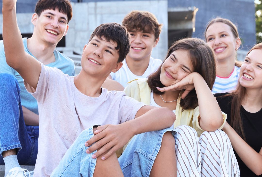 A group of young people smile taking a selfie
